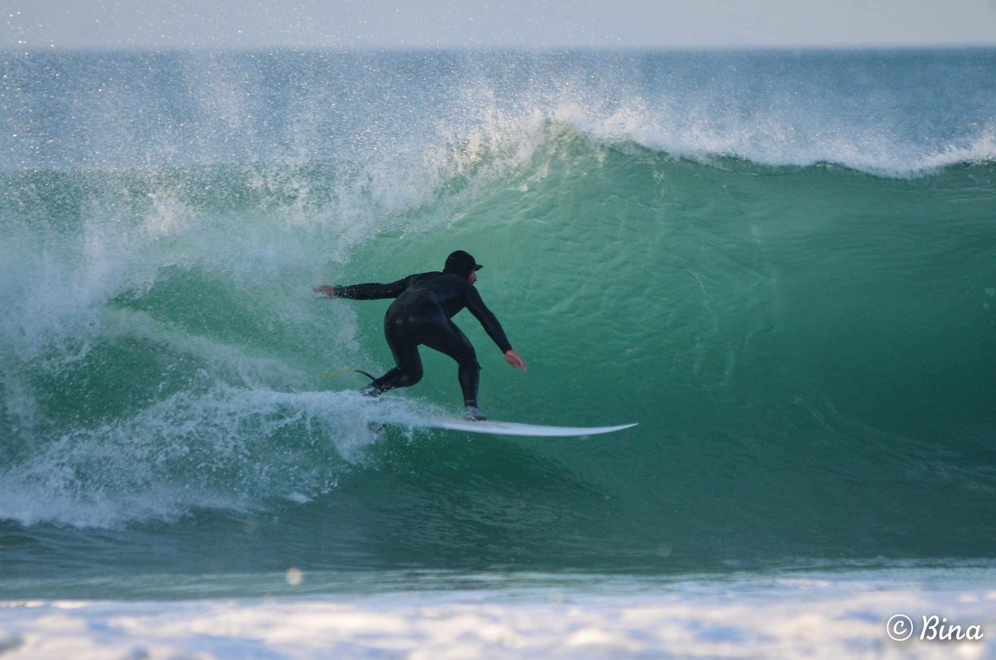 Surfeur sur une vague au Cap Fréhel, en Bretagne
